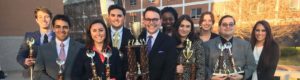 Members of the TCU Speech and Debate team holding trophies.