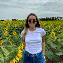 A photo of TCU student Sabrina Romero standing in a field of sunflowers.