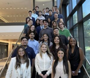 A group of college interns pose on a stairwell.