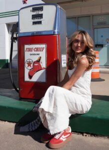 A student poses next to an old-school gas station pump.