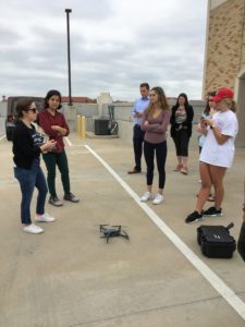 Jayne Orenstein stands in front of a group of students and explains the steps to take to successfully operate a drone. 