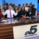 A group of journalism students pose on the anchor desk with Schieffer College alumnus Kris Gutierrez.