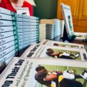 A photo of Schieffer College dean Kristie Bunton with stacks of her new book, "Having Their Say: Athletes and Entertainers and the Ethics of Speaking Out."