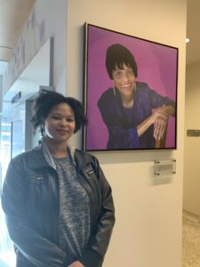 photo of Melissa Perkins '18 standing next to the portrait