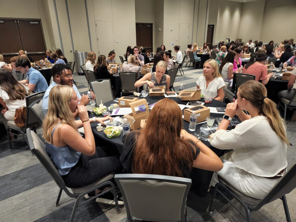 Students eat dinner around several tables at the Amon Carter Event Center.