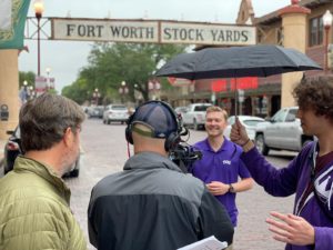 A photo of TCU student Ryan Marks filming with "The College Tour" crew.
