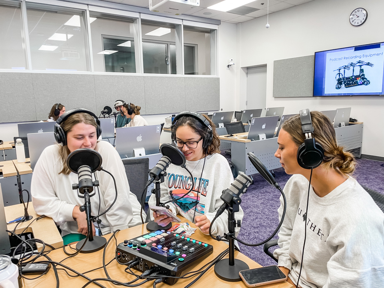 A group of students work on recording a podcast inside a TCU classroom.